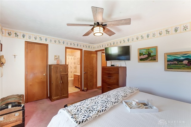 bedroom with connected bathroom, light colored carpet, and ceiling fan