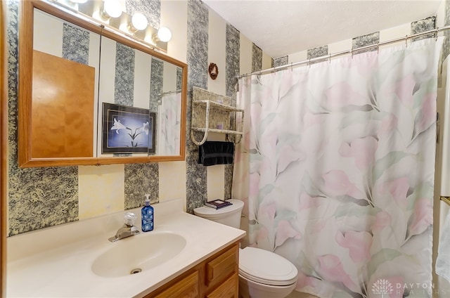 bathroom featuring curtained shower, vanity, and toilet