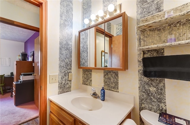 bathroom featuring vanity, a textured ceiling, and toilet