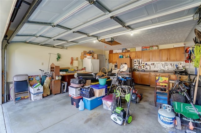 garage with white refrigerator and a garage door opener