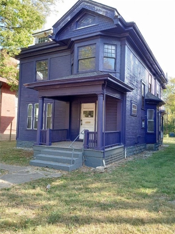 view of front of property with covered porch and a front lawn