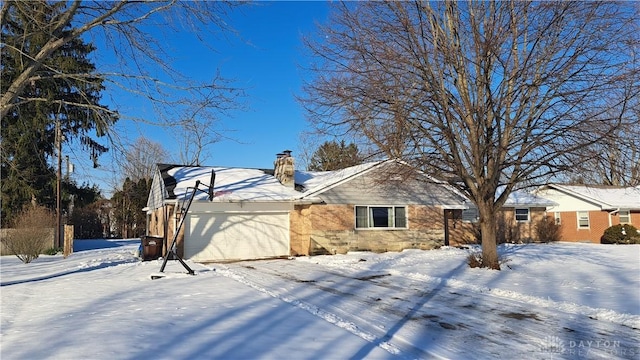 snow covered property featuring a garage