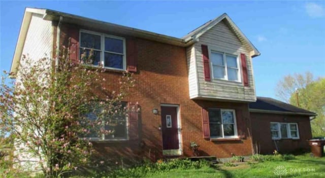 view of front of home with brick siding and a front lawn