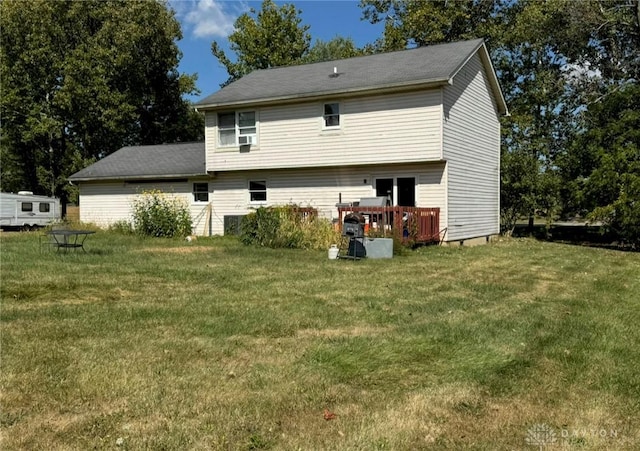 back of house featuring a lawn and a wooden deck