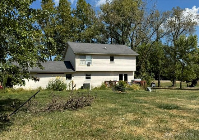 back of house with a yard and central AC