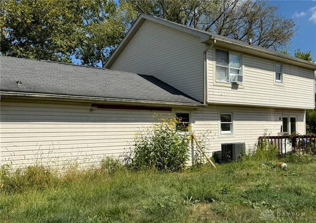 view of home's exterior featuring central AC and roof with shingles