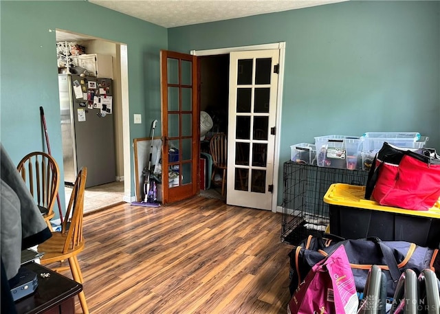 office space with french doors, a textured ceiling, and wood finished floors