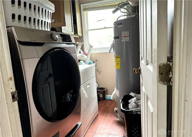 clothes washing area featuring water heater, separate washer and dryer, and dark wood-type flooring