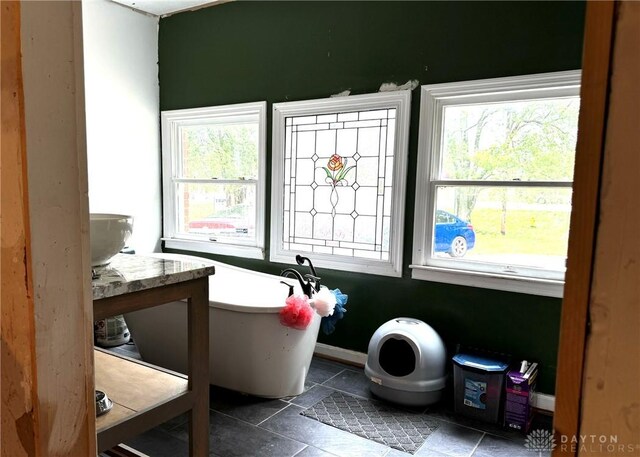 bathroom featuring a tub to relax in, vanity, toilet, and tile patterned floors