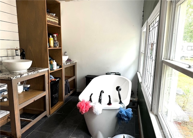 interior space featuring vanity, tile patterned flooring, and a tub