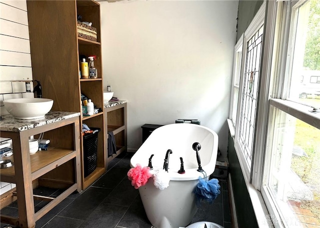 full bath with a freestanding tub, vanity, and tile patterned floors