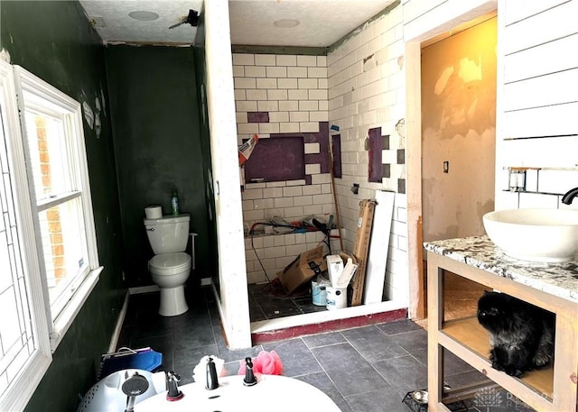 bathroom featuring a textured ceiling, vanity, and toilet