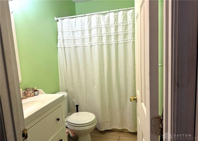 bathroom with walk in shower, hardwood / wood-style floors, vanity, and toilet