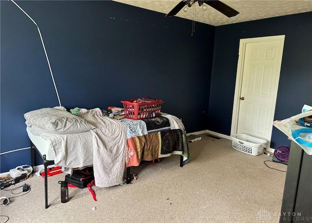 bedroom featuring ceiling fan, a textured ceiling, baseboards, and carpet flooring