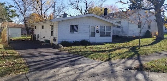 view of front of home with central AC unit and a front lawn