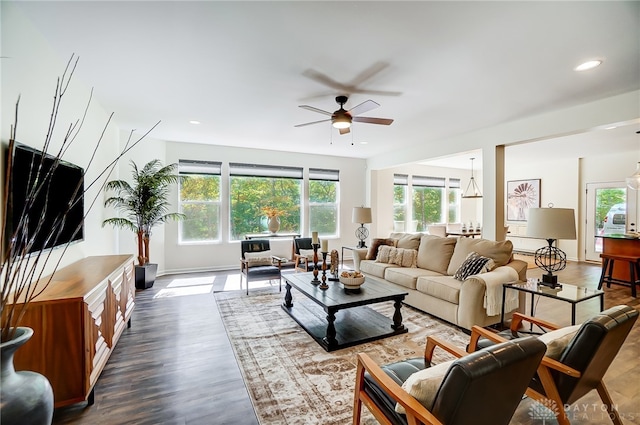 living room featuring ceiling fan and dark wood-type flooring