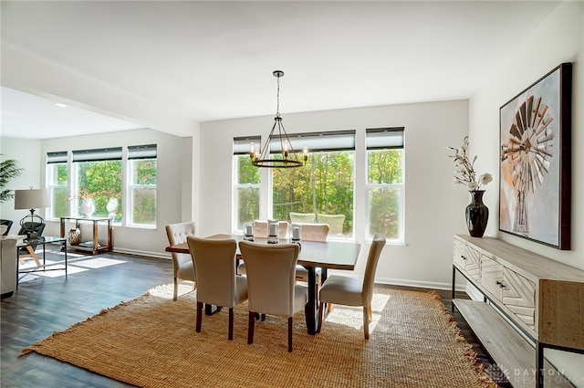 dining space with dark hardwood / wood-style flooring and a notable chandelier