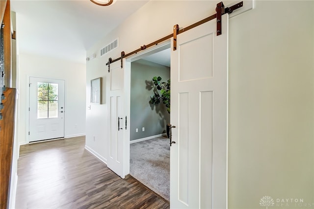 entrance foyer featuring a barn door and dark hardwood / wood-style flooring