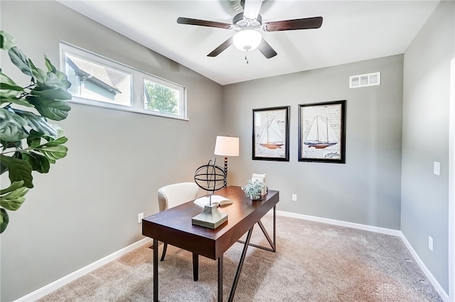 carpeted home office featuring ceiling fan