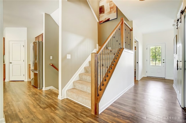 foyer with a barn door and dark hardwood / wood-style flooring