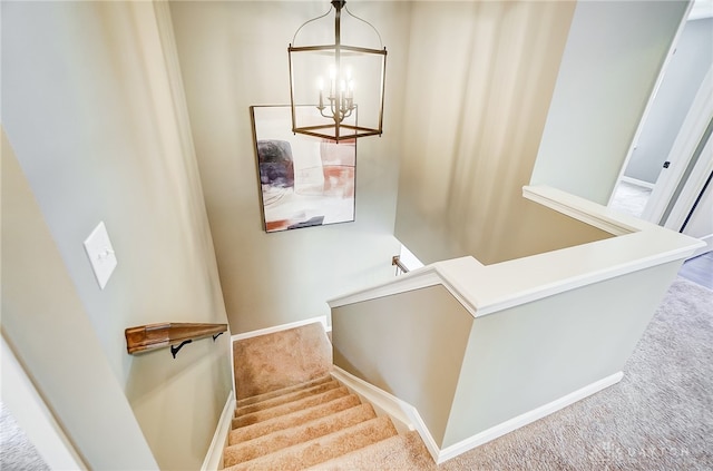 staircase featuring carpet and a notable chandelier