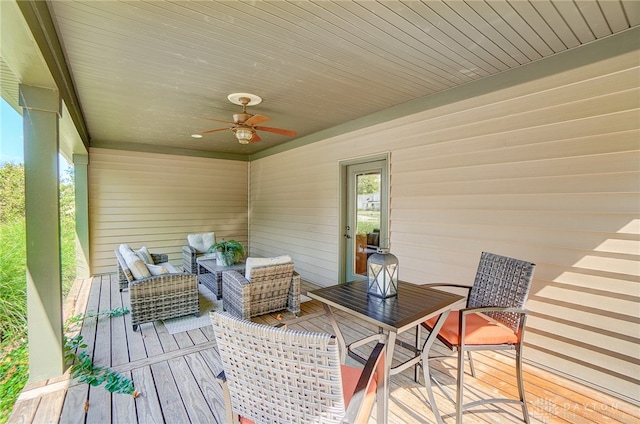 wooden terrace featuring ceiling fan and an outdoor living space