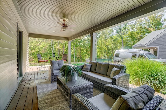 wooden deck with outdoor lounge area and ceiling fan