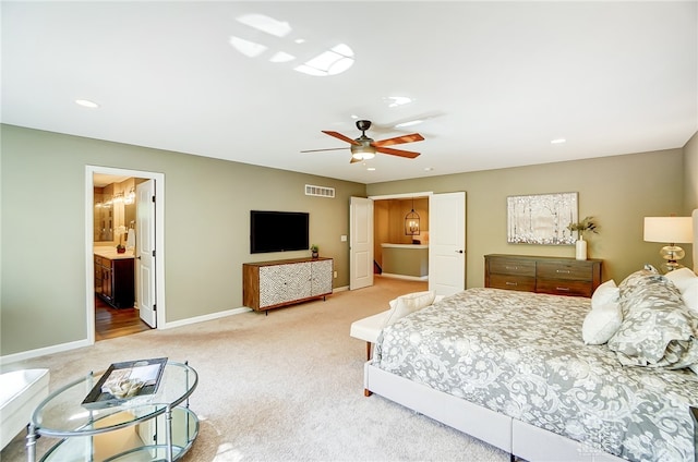 bedroom with ceiling fan, carpet floors, and ensuite bathroom