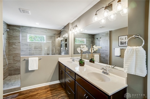 bathroom featuring a tile shower, vanity, and hardwood / wood-style flooring