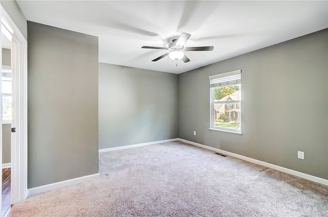 carpeted spare room featuring ceiling fan