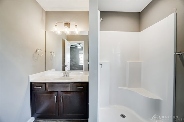 bathroom with vanity, ceiling fan, and a shower