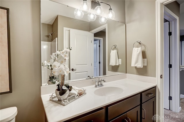 bathroom with vanity, toilet, and walk in shower