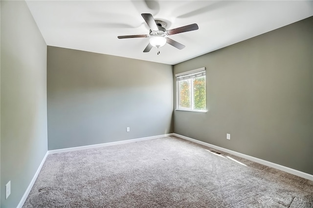 carpeted spare room featuring ceiling fan