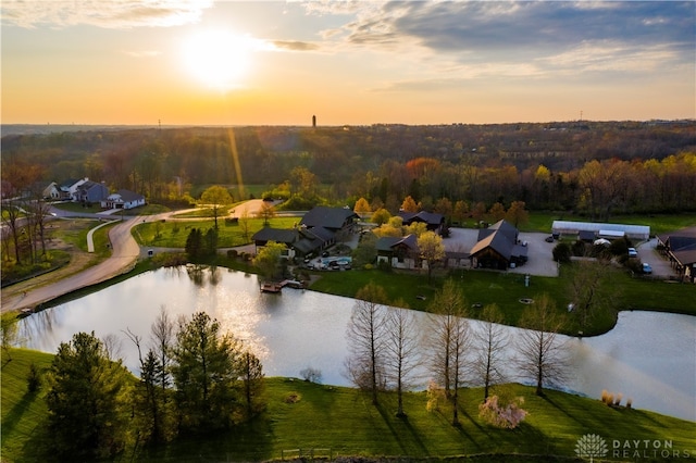 aerial view at dusk featuring a water view