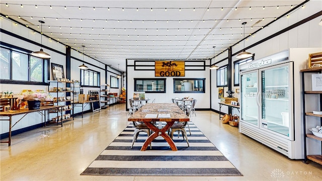 dining room with concrete floors and a high ceiling