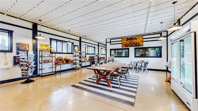 dining room with concrete flooring and a high ceiling