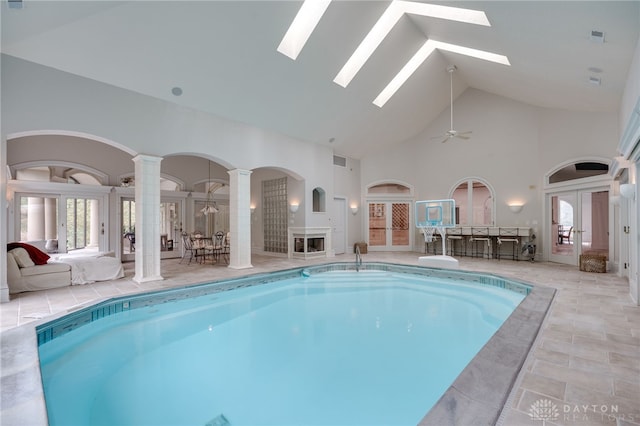 view of pool featuring ornate columns, ceiling fan, a skylight, and french doors