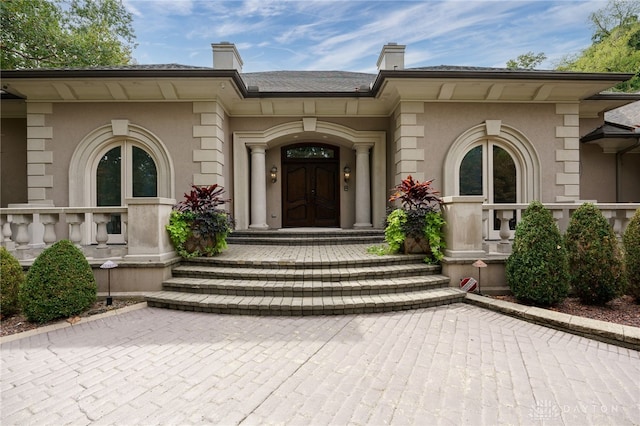 property entrance featuring covered porch and french doors