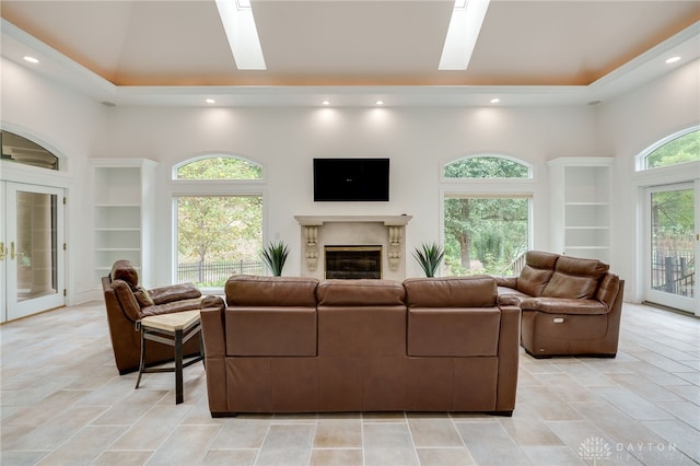 tiled living room with built in shelves, a skylight, a fireplace, and a healthy amount of sunlight