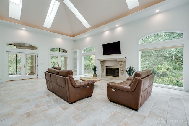 tiled living room featuring a high ceiling, a skylight, and french doors