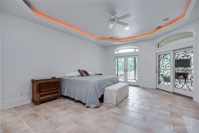 bedroom with ceiling fan, a raised ceiling, light tile patterned floors, french doors, and access to exterior