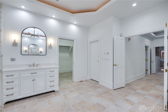 bathroom with vanity, a tray ceiling, and tile patterned flooring