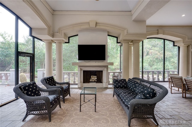 sunroom featuring a fireplace and ornate columns