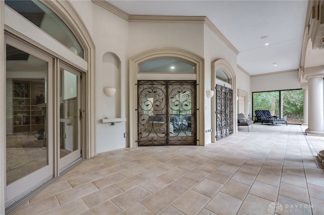 interior space featuring ornamental molding and decorative columns