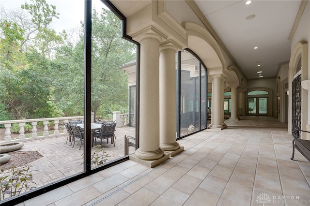 unfurnished sunroom with ornate columns