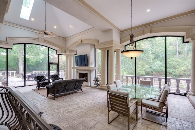 dining room with ceiling fan, ornate columns, plenty of natural light, and lofted ceiling with skylight