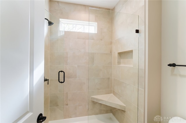 bathroom featuring a shower with door