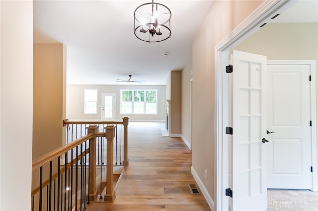 hall featuring light hardwood / wood-style floors and a chandelier