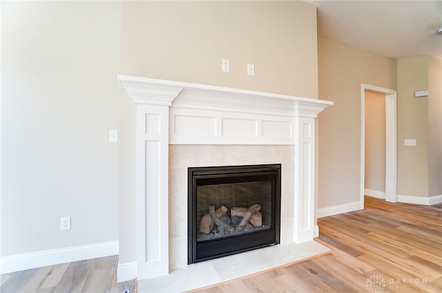 room details featuring a tiled fireplace and hardwood / wood-style floors