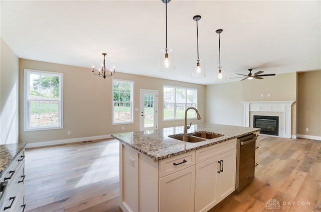 kitchen with light hardwood / wood-style floors, white cabinetry, sink, and a wealth of natural light